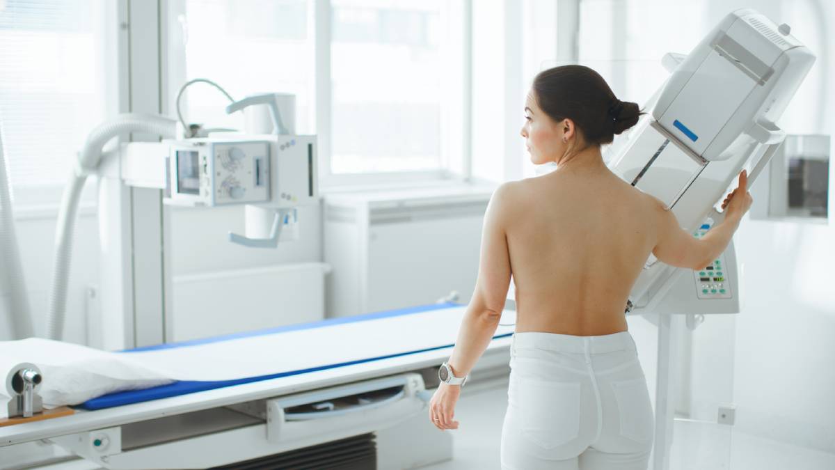 Woman standing waiting for a mammogram.